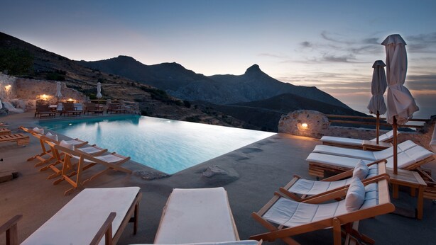 A poolside area with lounge chairs and umbrellas, overlooking a mountainous landscape. - Thalori (Gortyna)