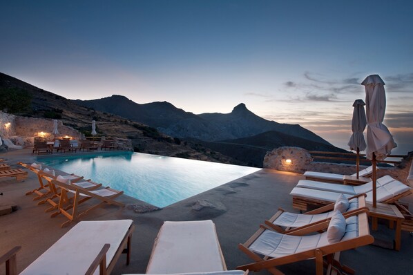 Alberca al aire libre, sombrillas en la alberca y camastros