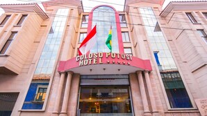 The exterior of Coloso Potost Hotel with a prominent sign and two flags. - Coloso Potosi (Potosi)