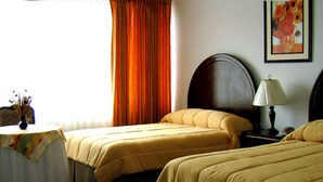A hotel room with two beds, a table with a vase of flowers, a lamp, and a painting on the wall. - Coloso Potosi (Potosi)