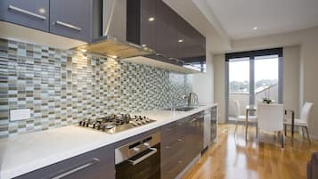 Deluxe Apartment (Number 4 - 1 Queen and 1 Tri-bunk) | Private kitchen | Full-sized fridge, microwave, stovetop, dishwasher