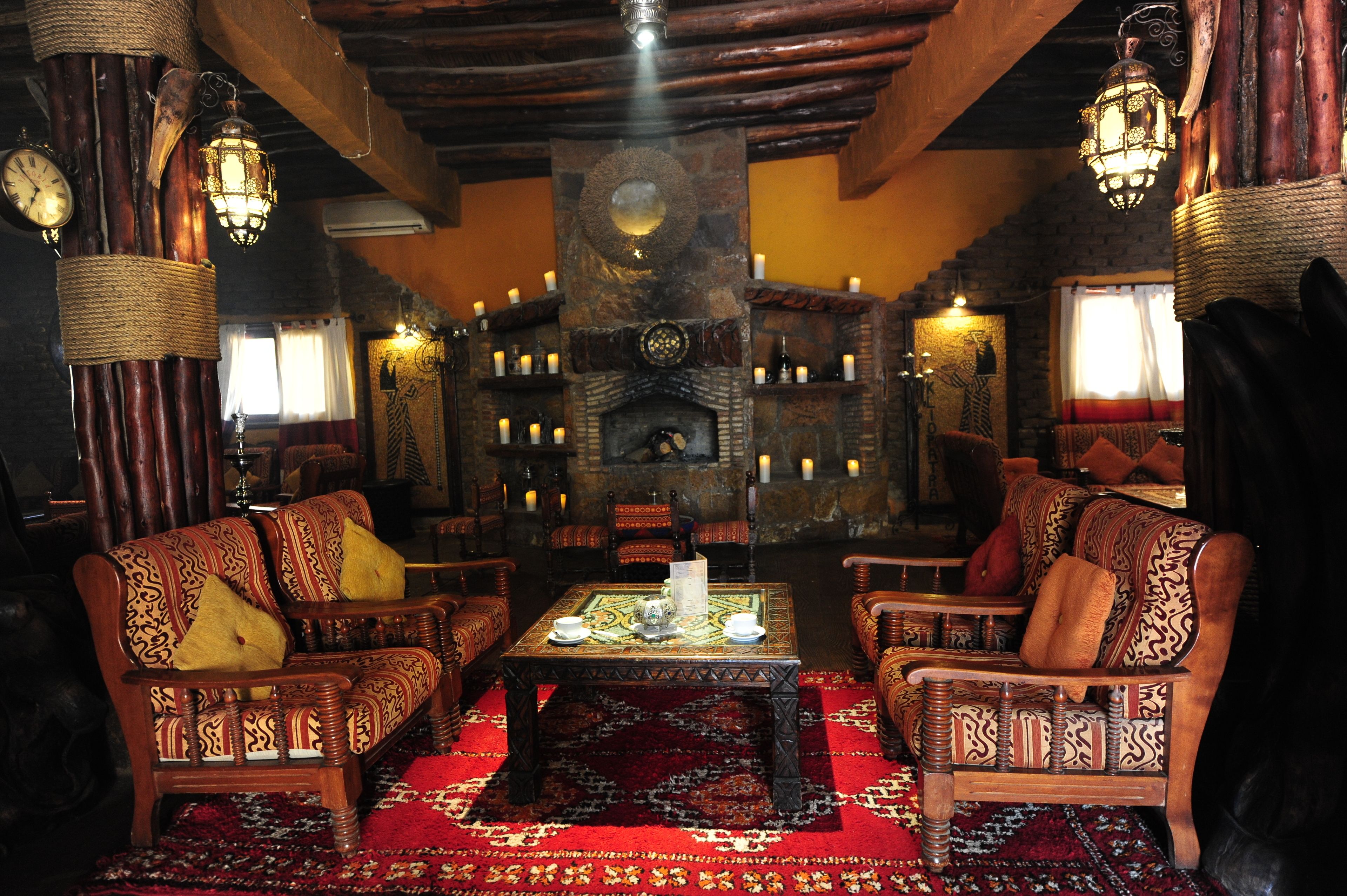 Un interior tradicional con muebles de madera, una chimenea central e iluminación decorativa.