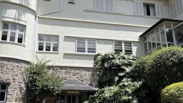 Um edifício com fachada de pedra, um alpendre com mobiliário exterior e uma placa com a inscrição 'HOTEL'.