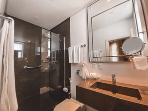 A modern bathroom with a glass-enclosed shower, a large mirror, and a vanity with a sink. - Hotel Casacurta (Garibaldi)