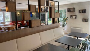 A modern interior with a sofa, tables, and shelves with books and decorative items.
