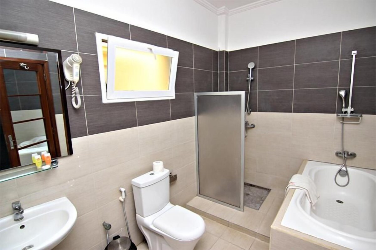 A bathroom with a toilet, sink, shower, and bathtub.
