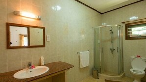 Un baño con lavabo, espejo, ducha e inodoro.