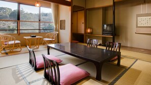 A traditional Japanese-style room with tatami flooring, a low table, and seating. - Ryotei Yamanoi Hotel (Matsue)