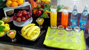 En presentation med frukt och dryck, innehållande olika sorters frukt, flaskor och glas.