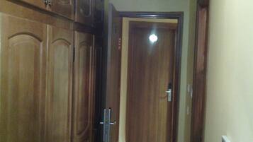 A hallway with wooden doors and a tiled floor.