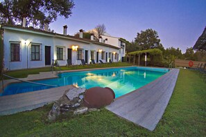 A swimming pool with lounge chairs and a house in the background. - Hotel Galaroza Sierra (Galaroza)