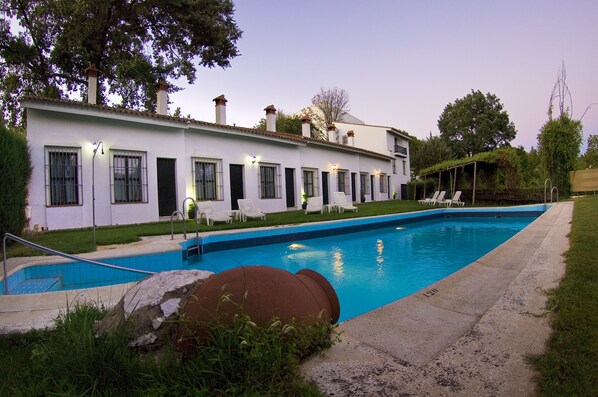 A white building with a swimming pool, outdoor seating, and a covered area. - Hotel Galaroza Sierra (Galaroza)