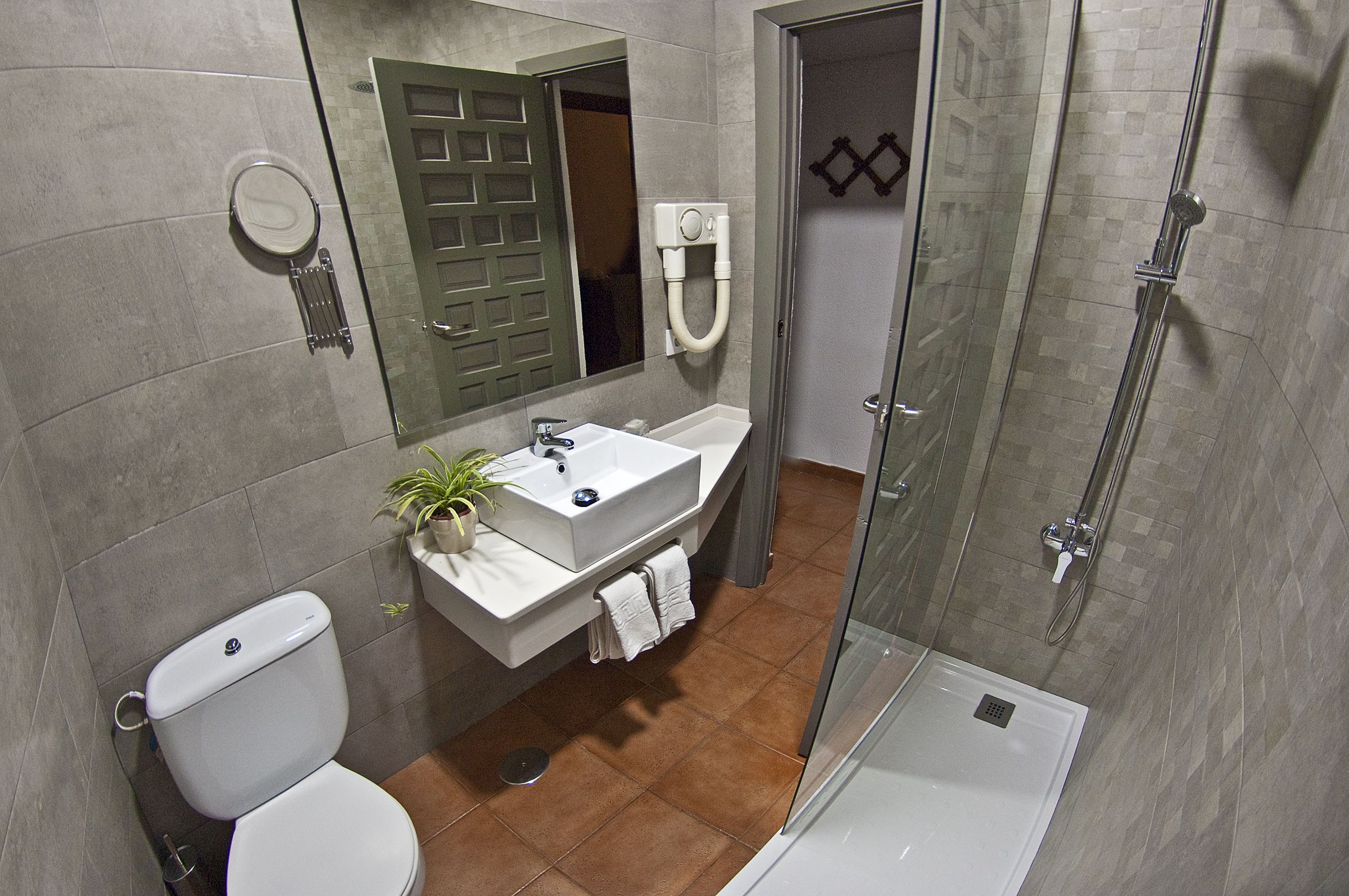 A modern bathroom with a toilet, sink, and shower.