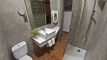 A modern bathroom with a toilet, sink, and shower.