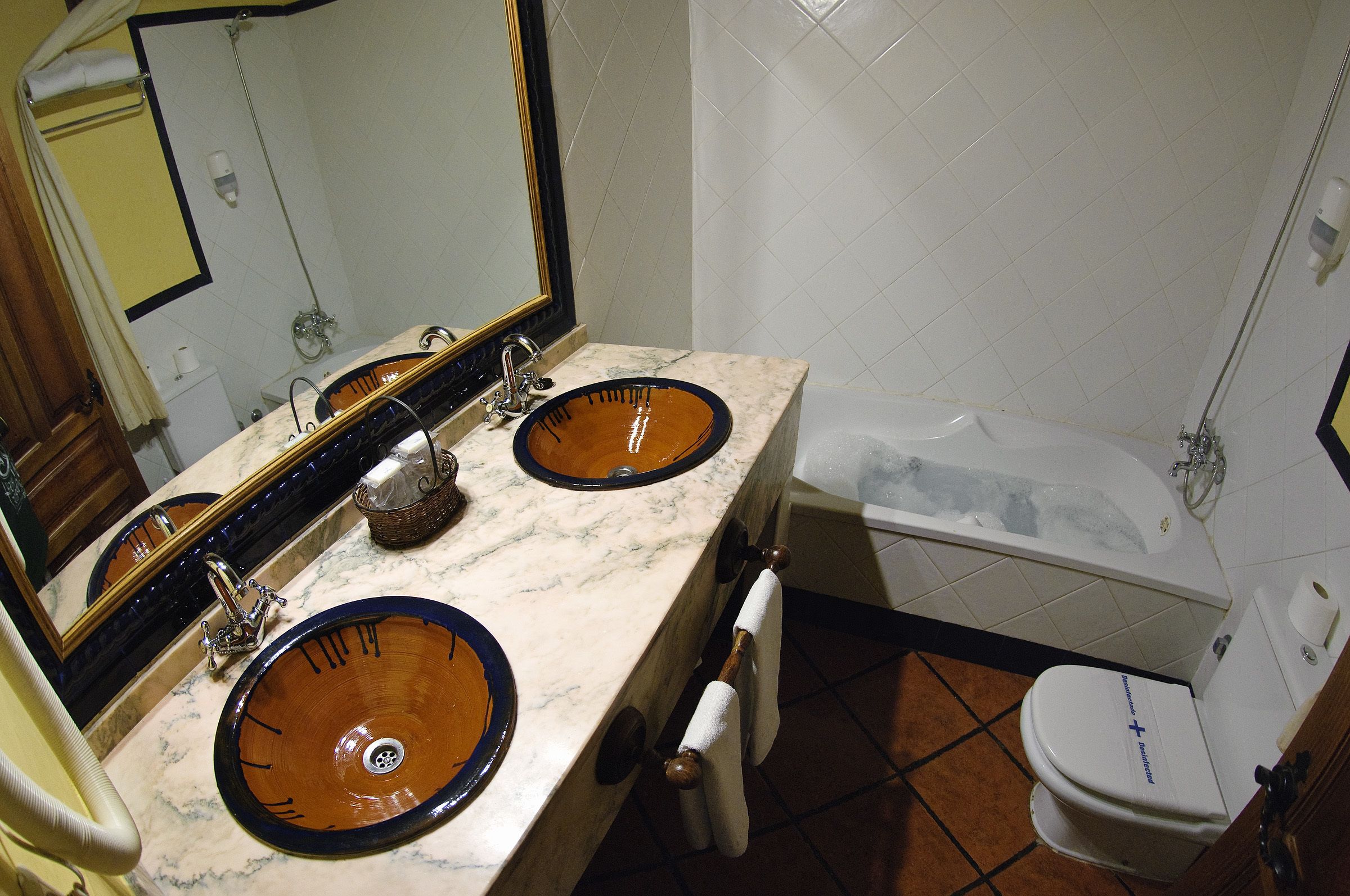 Un baño con dos lavamanos, una bañera y un inodoro.