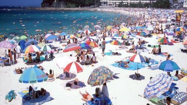 A crowded beach with numerous umbrellas and people sunbathing. - Kurhouse Shirahama (Shirahama)