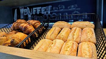 A display of various baked goods, including croissants and baguettes, in a bakery setting.