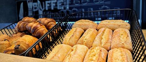 Una vitrina de panadería con cruasanes y barras de pan.