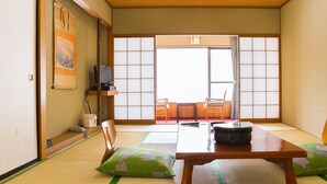 A traditional Japanese room with tatami flooring, a low table, cushions, and sliding doors. - Mori No Ryotei Mount Bandai (Inawashiro)