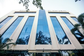 A modern hotel building with a reflective glass facade and a central entrance. - El Español Paseo de Montejo (Mérida)