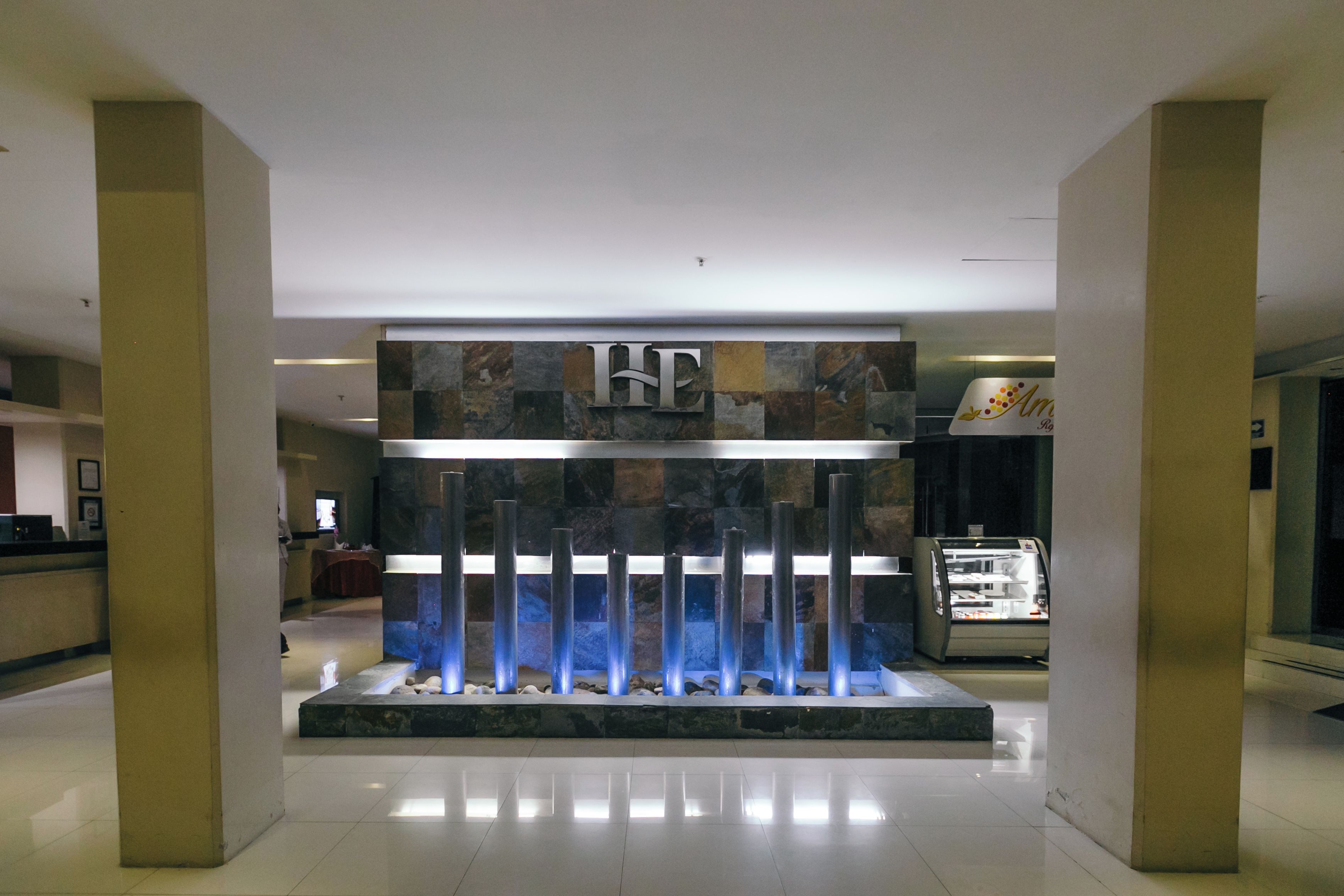 A reception area with a modern design, featuring a water feature and a reception desk.