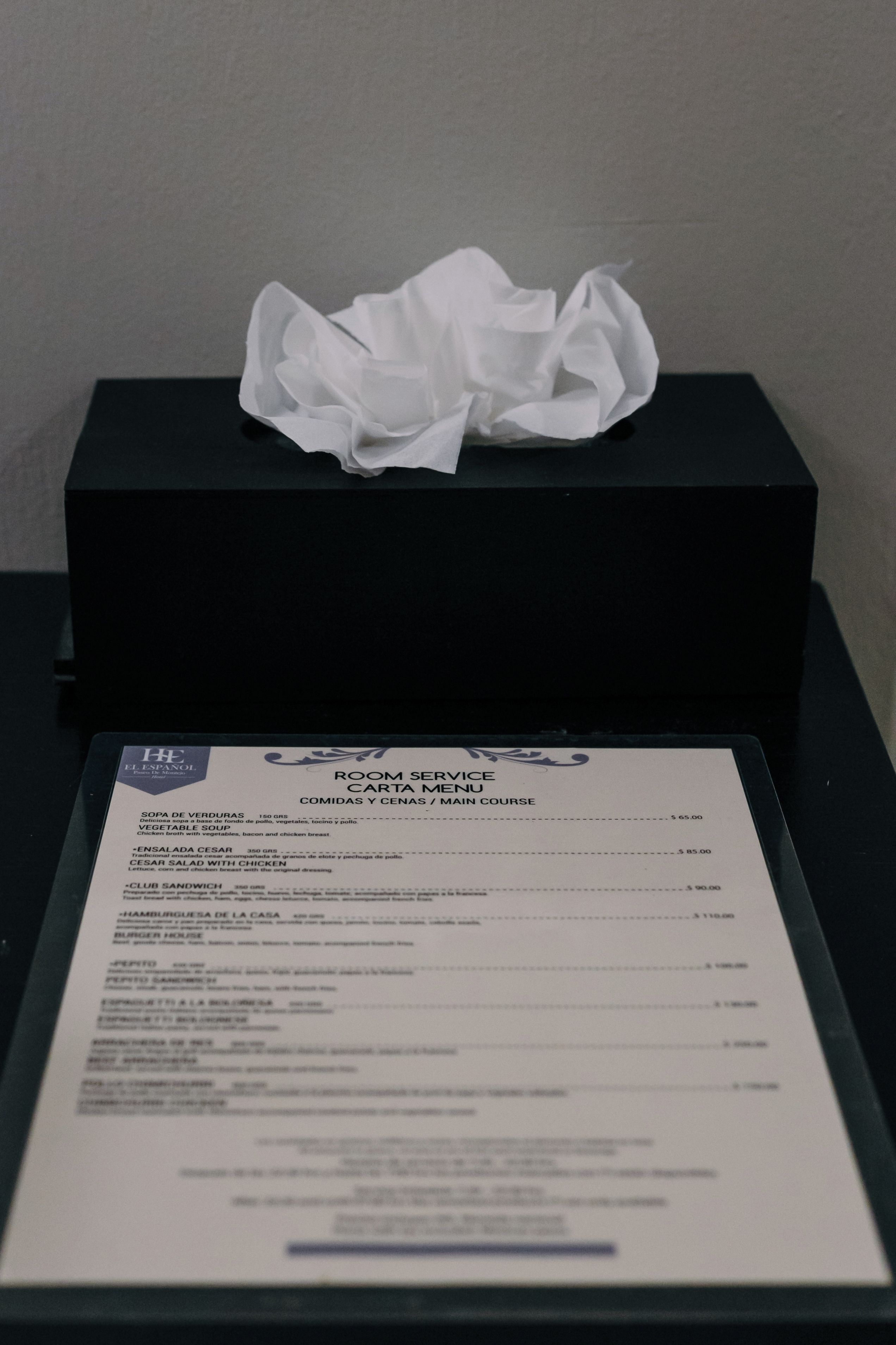 Une carte de menu intitulée « SERVICE EN CHAMBRE », avec une boîte noire contenant un mouchoir en papier blanc.