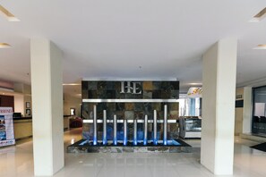 A reception area with a stone wall, a metal gate, and a sign with a letter 'E'. - El Español Paseo de Montejo (Mérida)