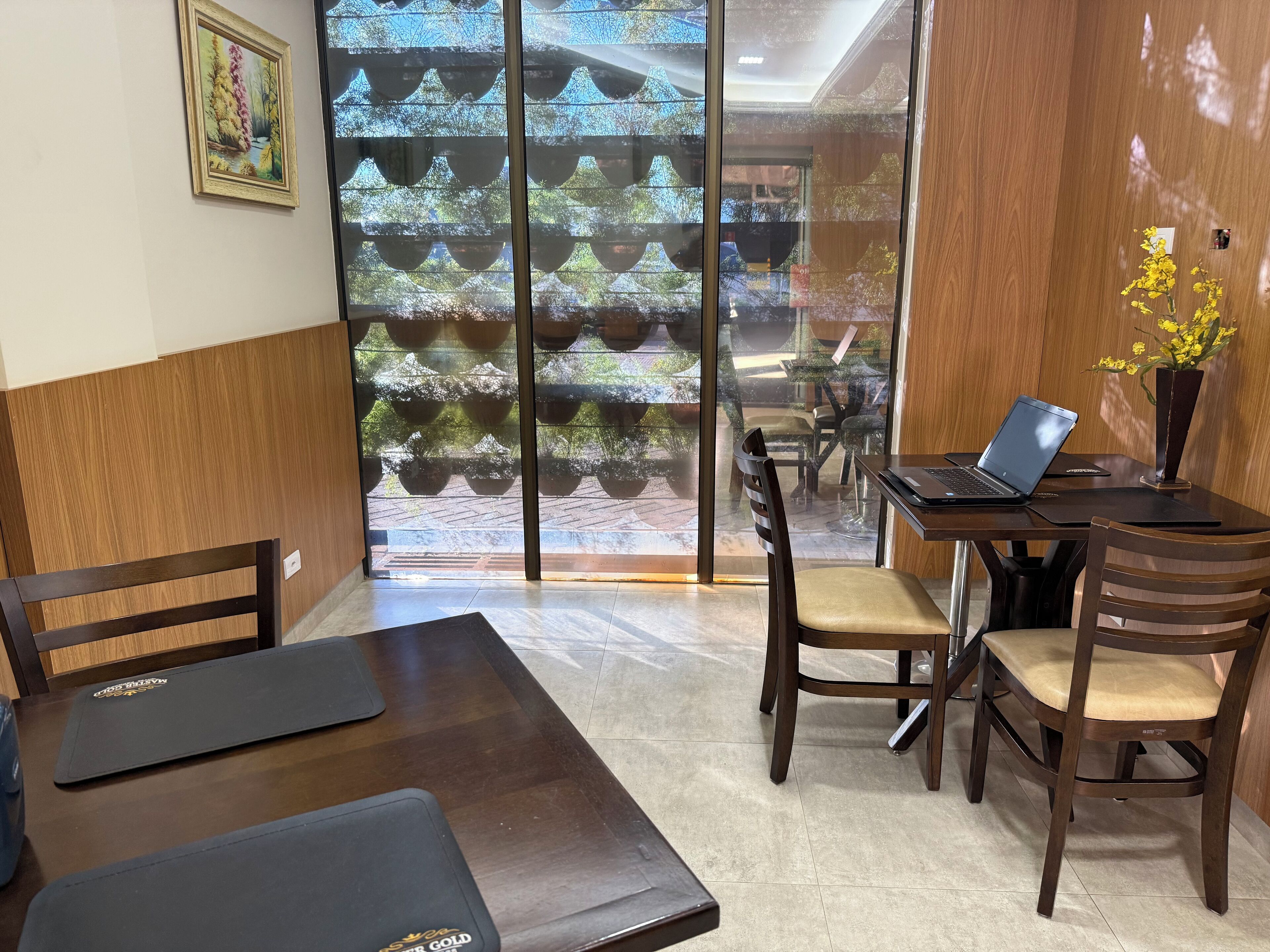 Un comedor moderno con una mesa de madera, sillas y un ordenador portátil sobre la mesa.