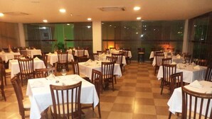 A restaurant with multiple tables and chairs, arranged in a spacious layout with a checkered floor pattern. - Morubixaba Hotel (BARREIRAS)