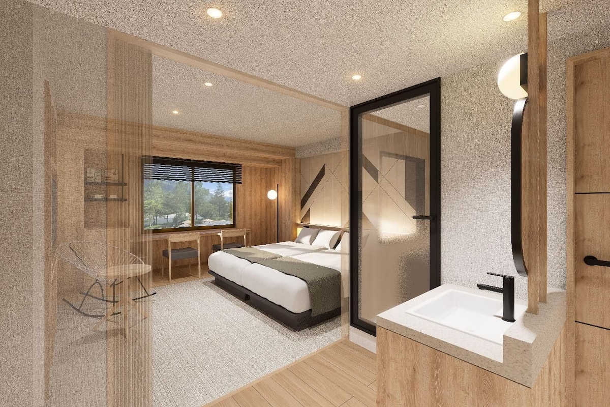 Quarto moderno com cama, mesa de cabeceira e uma janela grande.