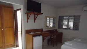 A hotel room with a bed, a desk with a computer, a television, and a window with blinds. - Pantanal Hotel (Miranda)