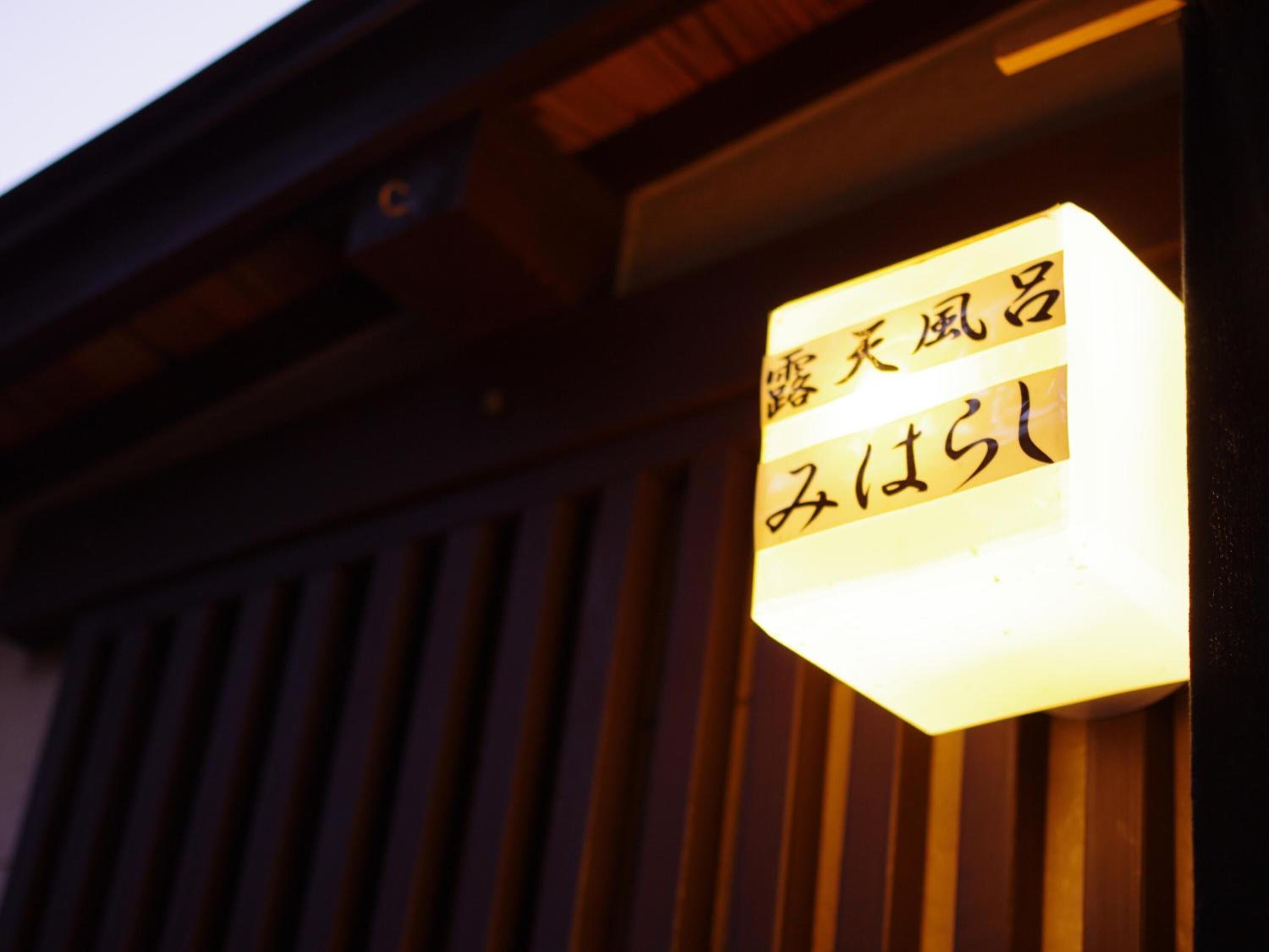 Une enseigne avec des caractères japonais sur un bâtiment.