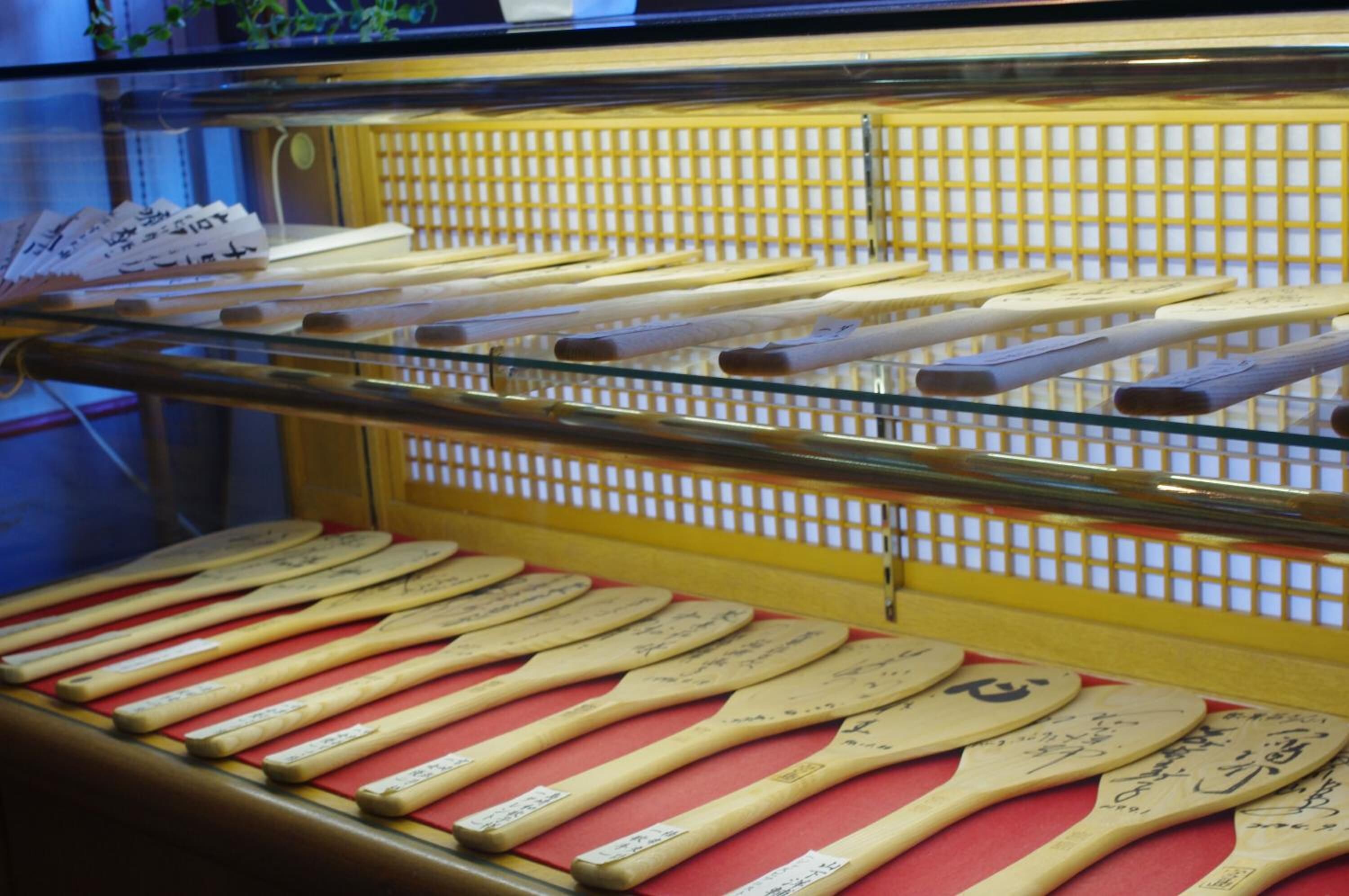 Una vitrina que contiene varias palas de madera, algunas con inscripciones.