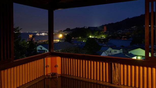 A balcony with a view of a traditional pagoda and residential buildings at dusk. - Jukeiso (Hatsukaichi)