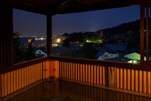 Un balcón con vistas a una pagoda tradicional y edificios residenciales al atardecer.