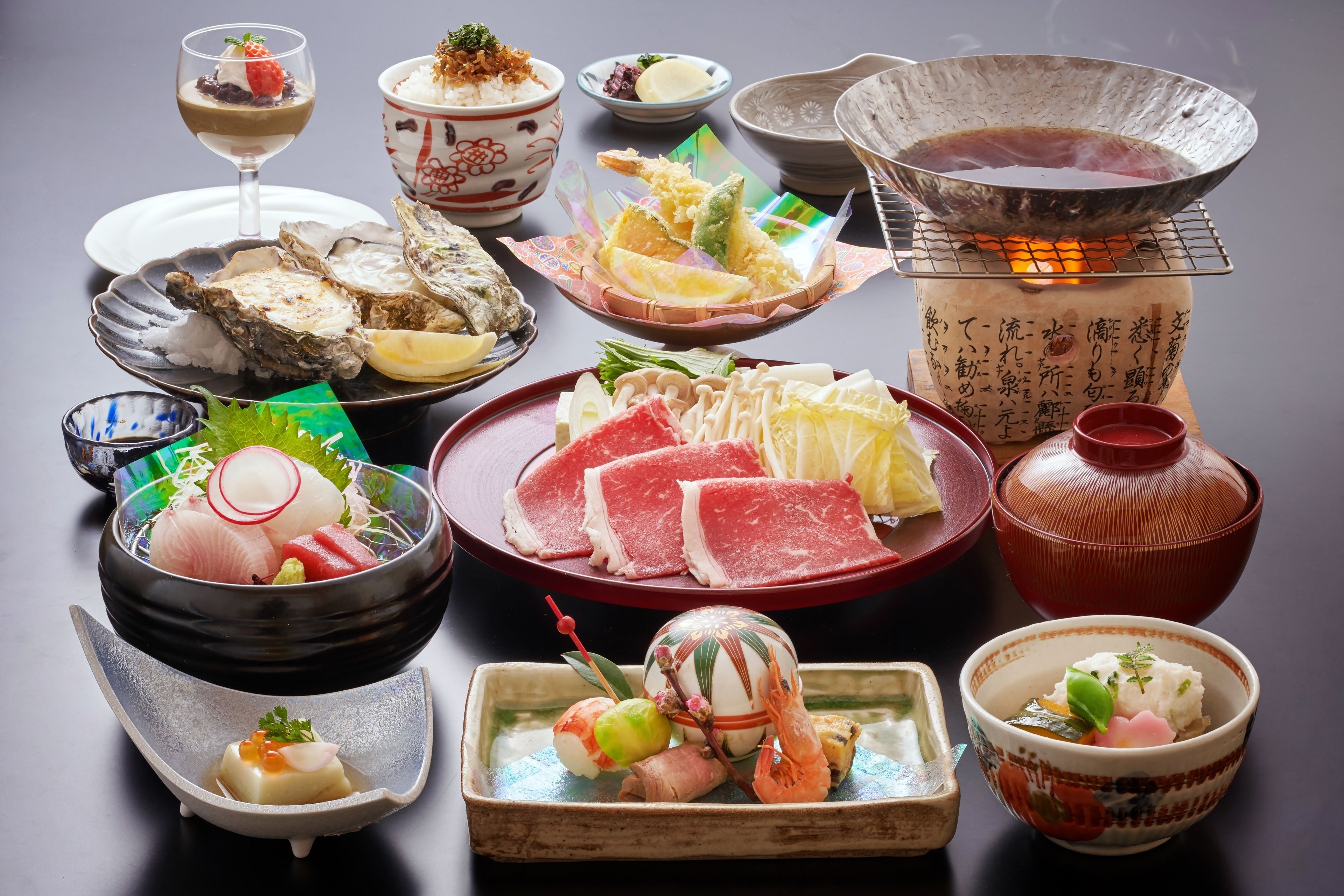 Une variété de plats japonais, notamment des sushis, des sashimis et un plat mijoté servi à table.