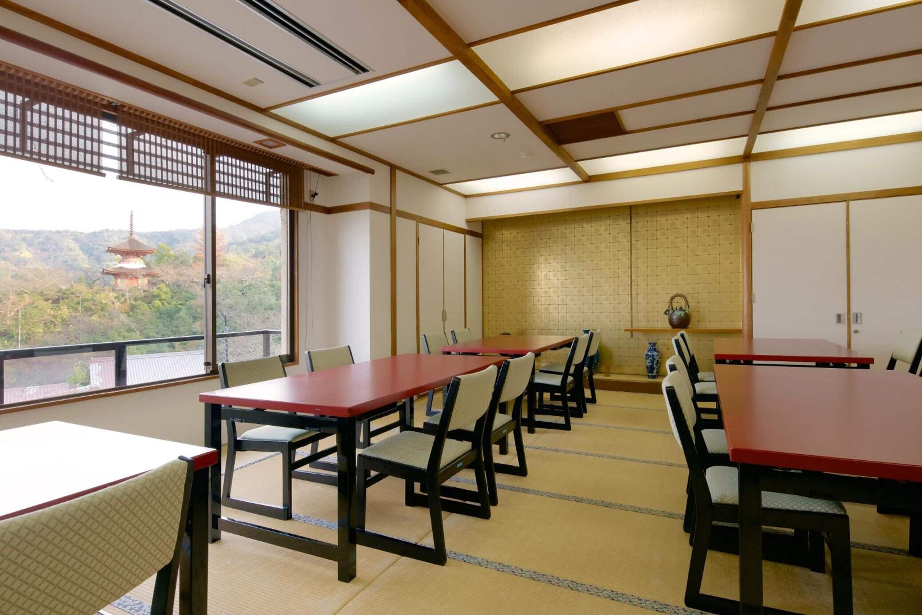 A traditional Japanese-style room with tatami flooring, low tables, and chairs.