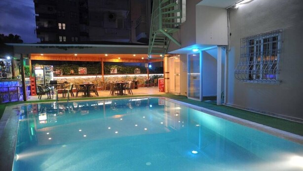 An indoor swimming pool with a bar area and seating. - Happy Homes Apartments (Alanya)