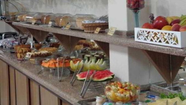 A buffet with various food items including fruits, vegetables, and bread. - Abib Hotel (IRATI)