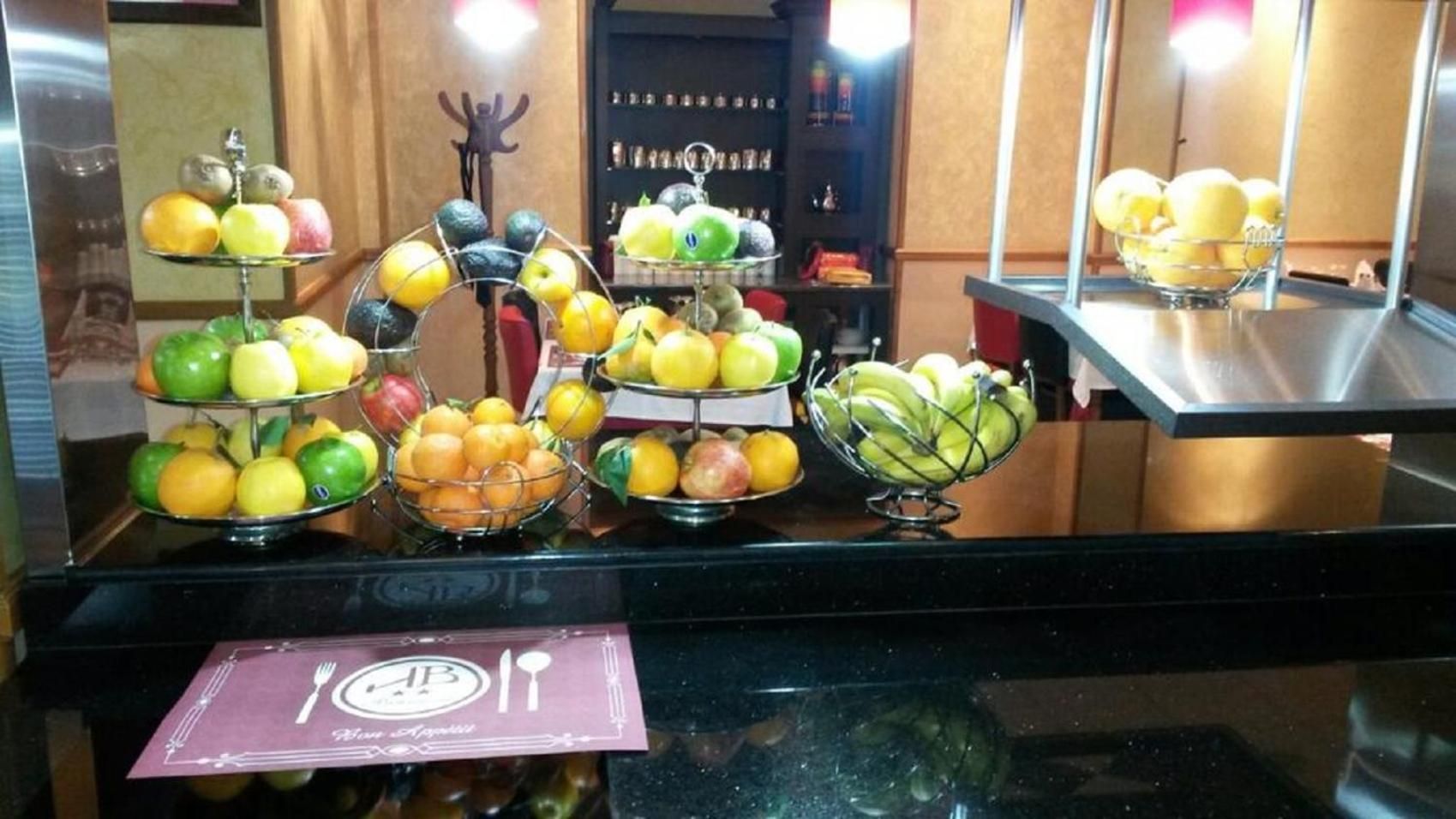 Un buffet proposant une variété de fruits présentés sur différents présentoirs.