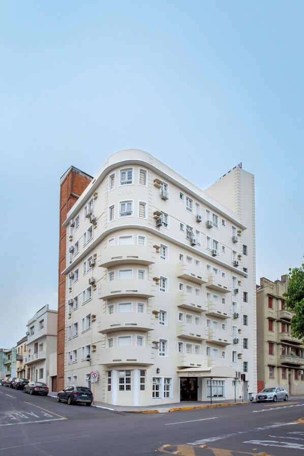 Ein mehrstöckiges Gebäude mit einer gebogenen Fassade, Nummer 1939, mit mehreren Balkonen und Klimaanlagen.