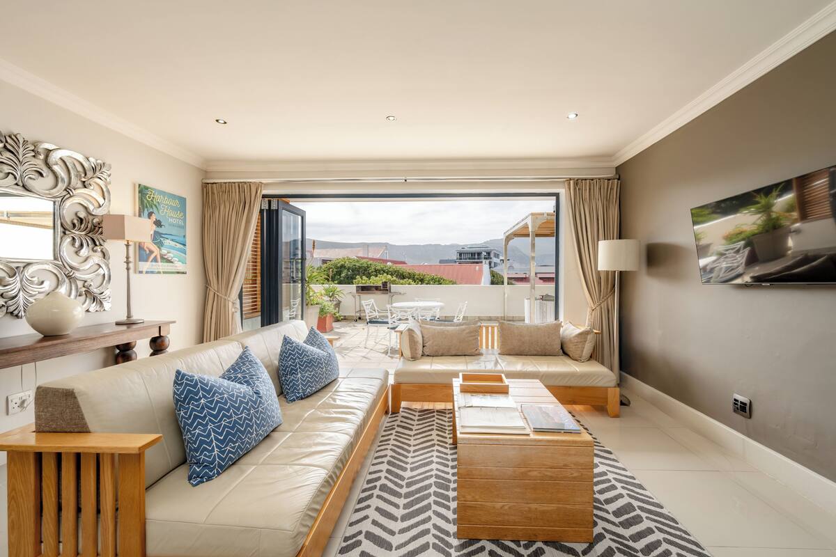 A modern living room with a sofa, coffee table, and a view of the outdoors.