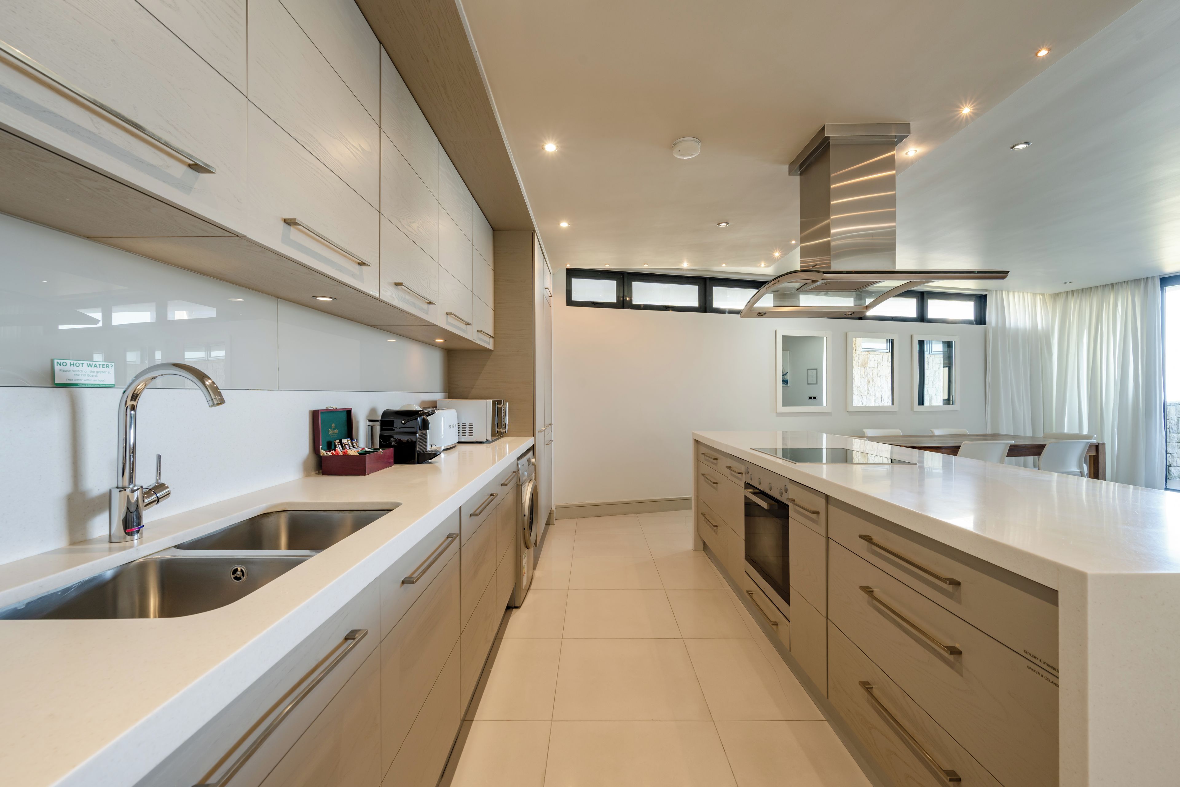 Una cocina moderna con electrodomésticos de acero inoxidable, horno empotrado y una isla grande con lavaplatos.