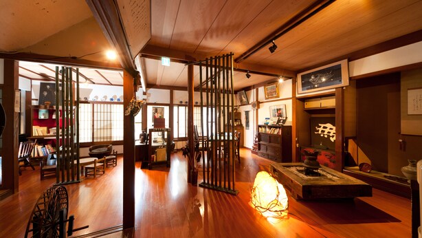 A traditional Japanese interior with tatami flooring, sliding doors, and a low wooden ceiling. - Kiya Ryokan (Misasa)