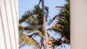 A beach view with a boat, palm trees, and lounge chairs. - Severin Sea Lodge (Mombasa)