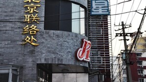 Un bâtiment à la façade incurvée, doté de grandes fenêtres et d’une enseigne en caractères chinois.