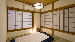 A traditional Japanese room with tatami flooring, shoji screens, and a futon bed. - Sheena and Ippei - Hostel (Tokyo)