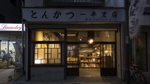 A storefront with large glass windows and a sign in a foreign language. - Sheena and Ippei - Hostel (Tokyo)