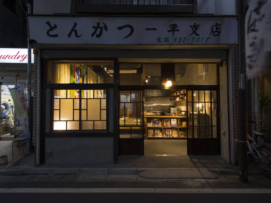 Ein Schaufenster mit großen Glasfenstern und einem Schild in einer Fremdsprache.