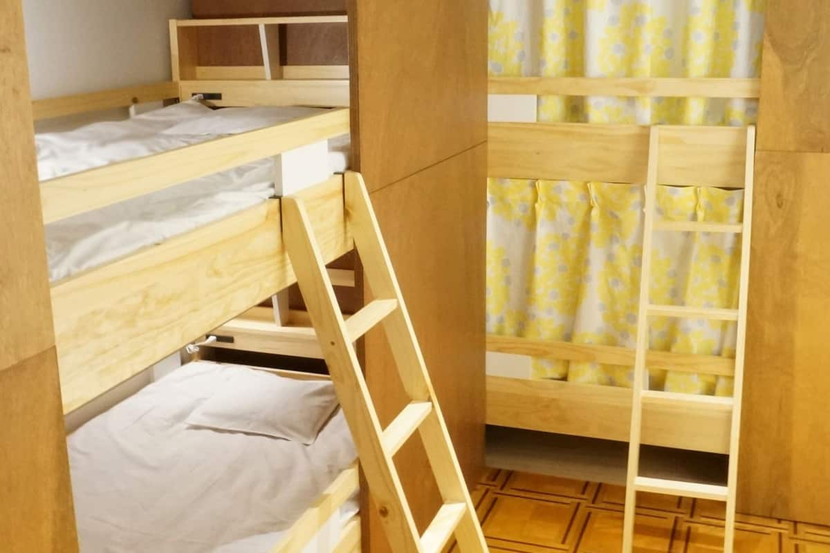 A bunk bed room with a wooden ladder and a patterned floor.